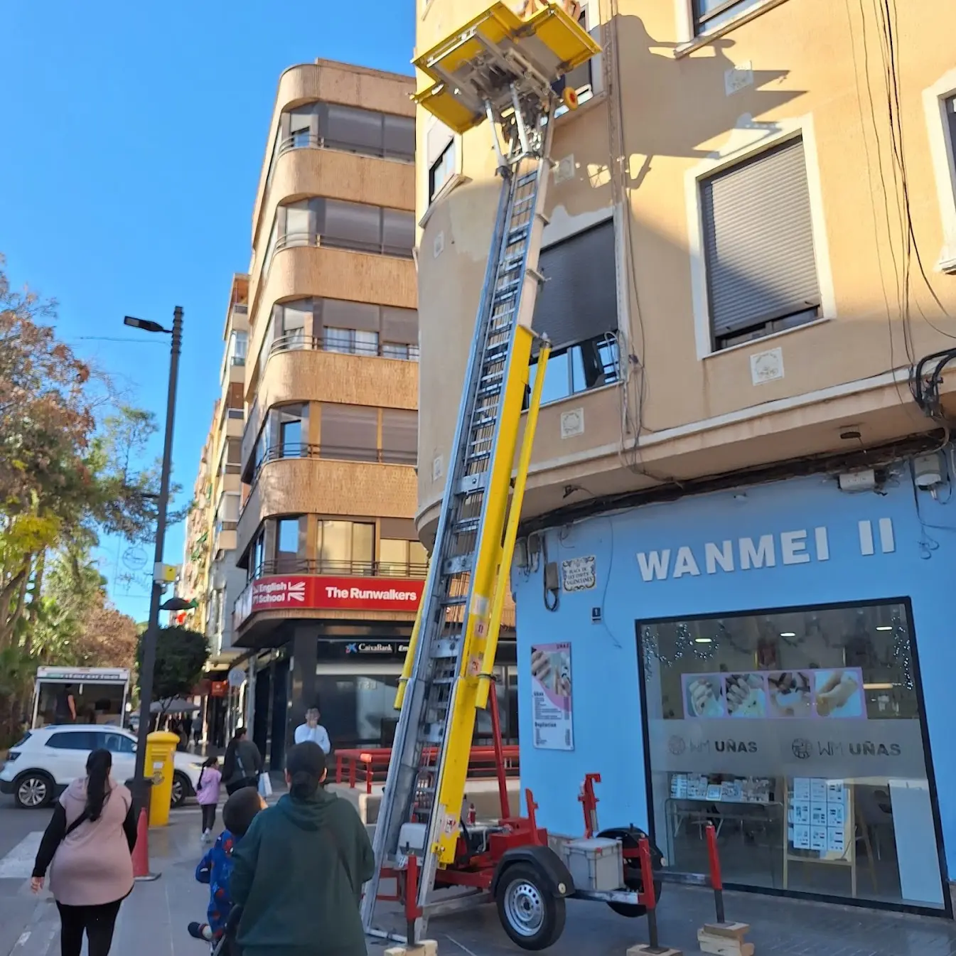 Elevador de fachada desplegado en la esquina de una avenida con señalización de la zona de trabajo