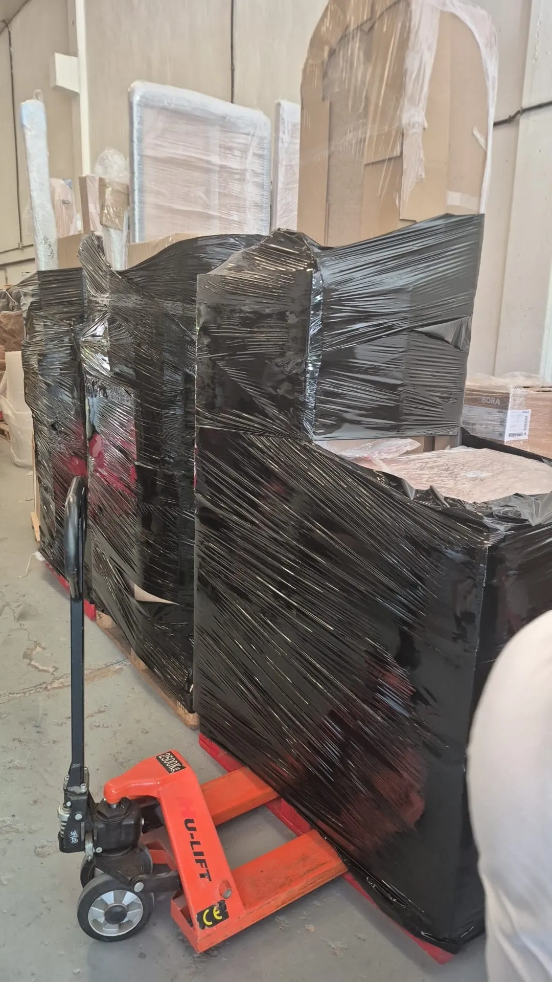 Lotes de mobiliario paletizado y retractado en la nave de guardamuebles de Zaragonjg junto a una transpaleta